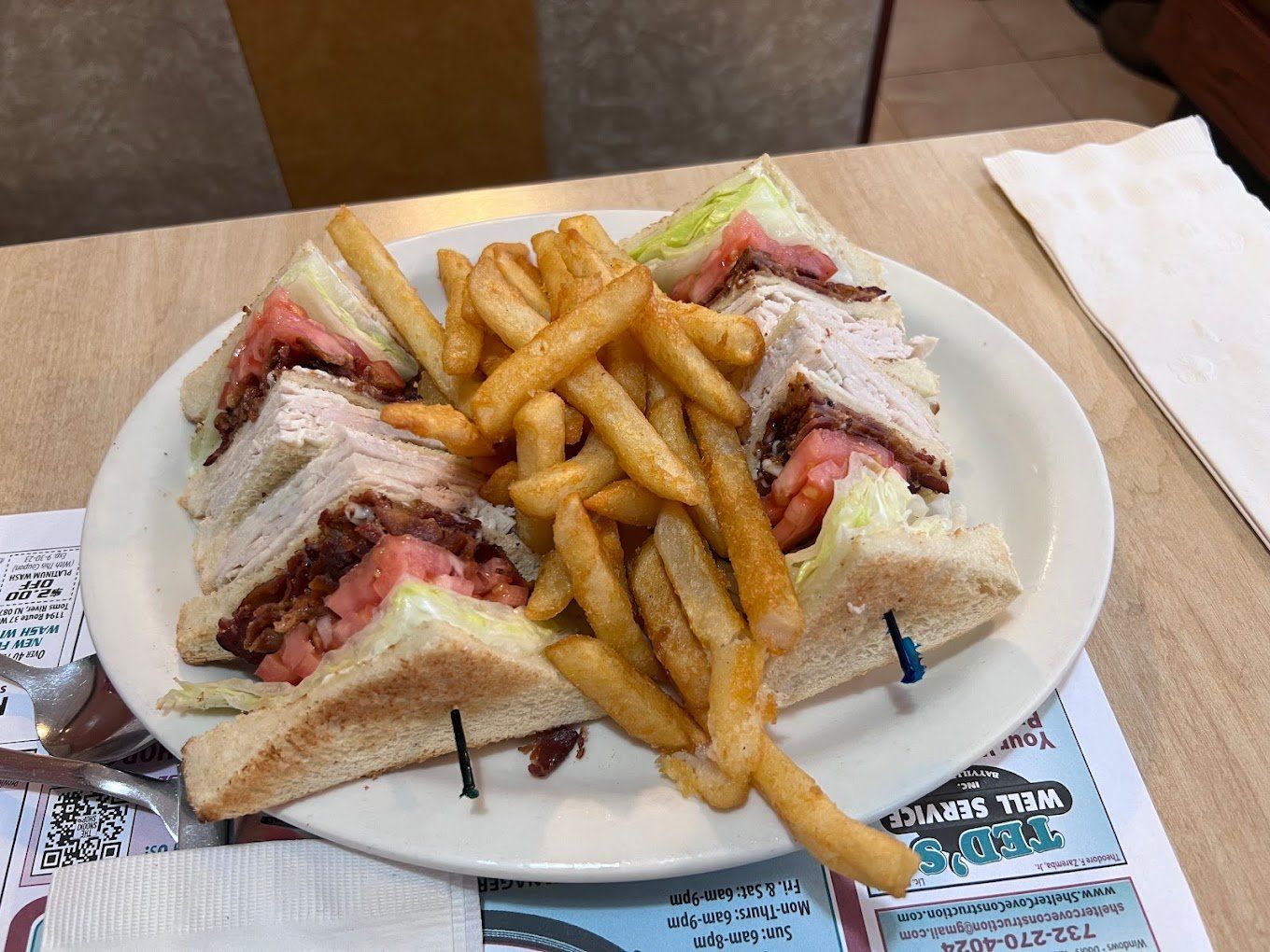 A triple-decker club sandwich cut in quarters, with French fries
