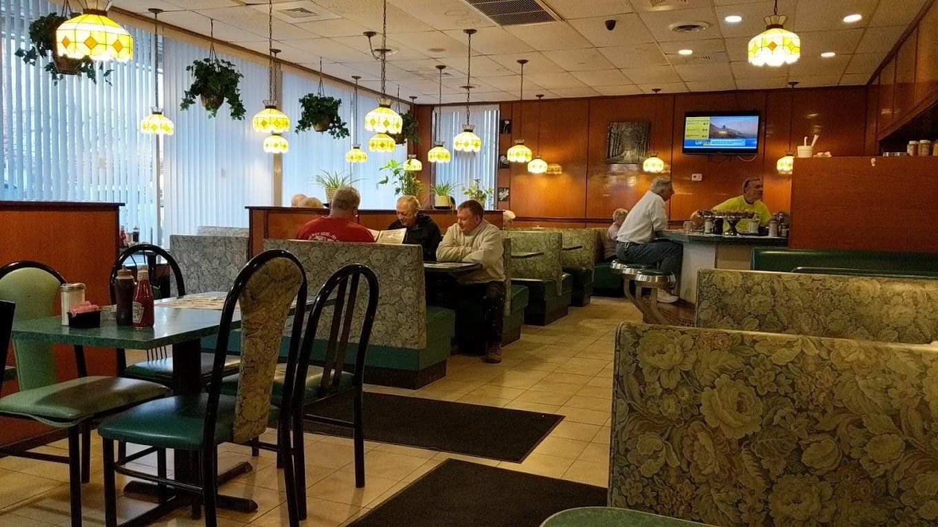 The dining room: booths along the windows, stained-glass lamps hanging over the tables and the counter